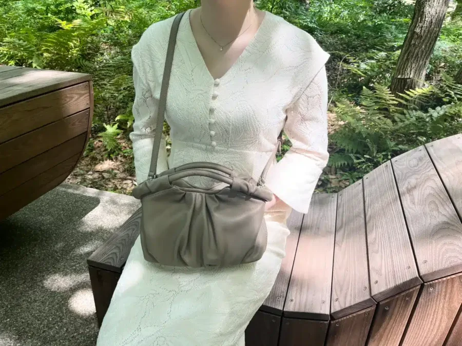 土屋鞄のラッフル 2way ギャザーショルダーを斜め掛けした女性