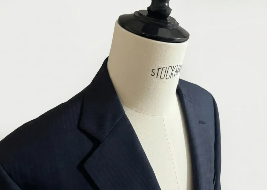 私物のオーダースーツSADAのジャケットがトルソーに掛けられている。斜め上からのアングルの画像。色柄はネイビーのシャドーストライプ。