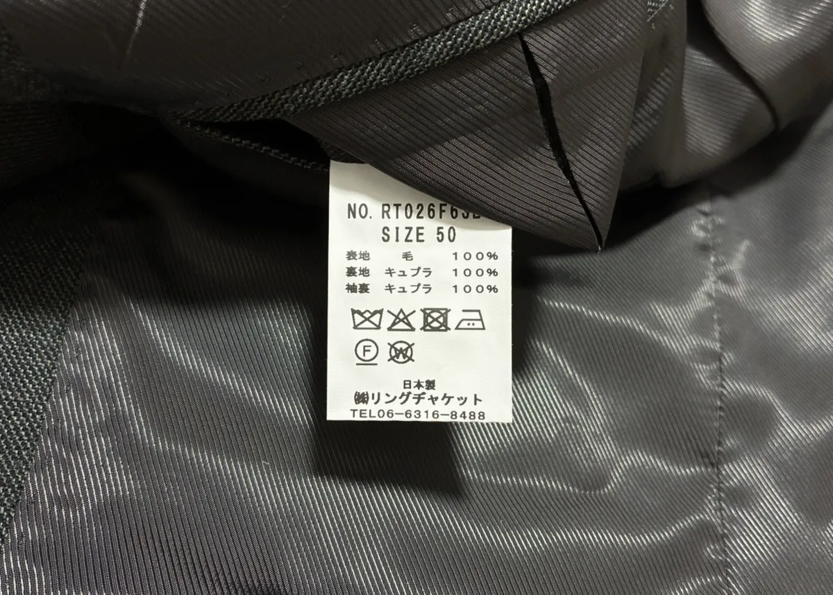 私物の品質表示。品番RT026F63B、サイズ50、表地毛100%、裏地と袖裏キュプラ100%、日本製