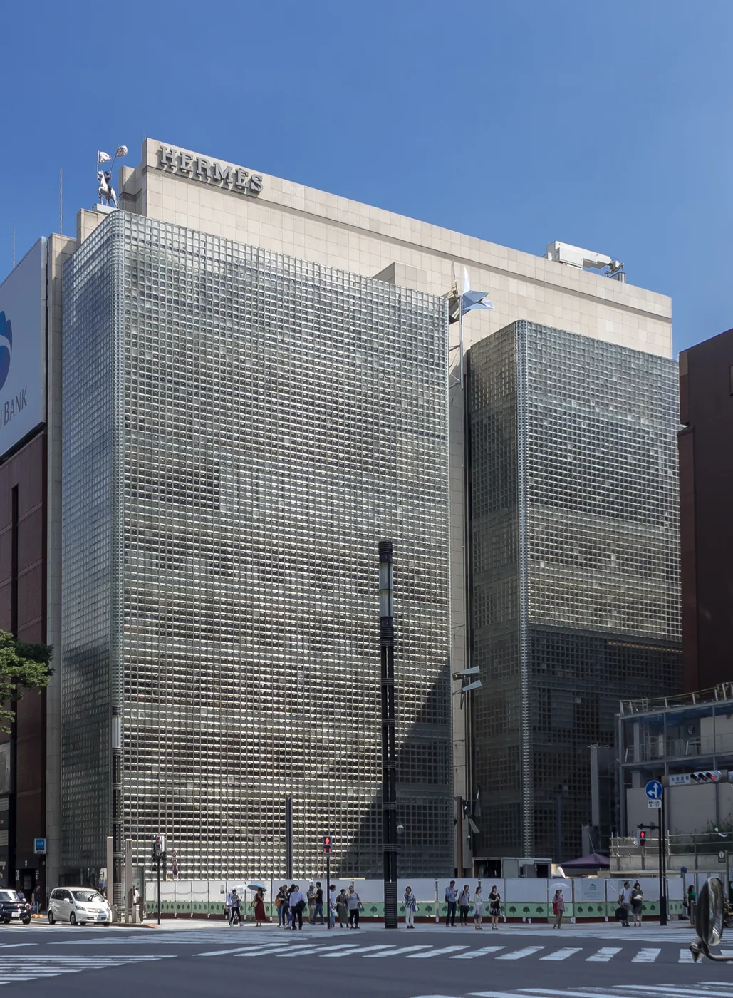 昼の銀座のメゾンエルメス。ガラスブロックで覆われた細長い建物が交差点に面して建っている
